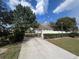 Long driveway leading to a charming home with a gated entrance and lush, green landscaping at 13738 State Road 33, Groveland, FL 34736