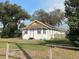 Quaint single-story home with mature trees, a charming fence, and a well-manicured lawn at 13738 State Road 33, Groveland, FL 34736