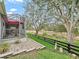 Relaxing screened-in back porch with a red umbrella overlooks the property's green space and mature trees at 1415 Bethune Way, The Villages, FL 32162