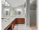 Well-lit bathroom with dual sinks, cherry wood cabinetry, white countertops, and a separate shower area at 1415 Bethune Way, The Villages, FL 32162