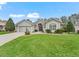 Lovely home showcasing a lush green lawn, beautiful landscaping, and a two-car garage at 1415 Bethune Way, The Villages, FL 32162