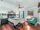 Comfortable main bedroom featuring a ceiling fan, wood floors, and a cozy sitting area at 1415 Bethune Way, The Villages, FL 32162