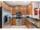 A functional kitchen featuring modern stainless steel appliances, granite countertops and wood cabinets at 14157 Oasis Cove Blvd # 104, Windermere, FL 34786