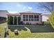 Green backyard features a screened patio, trimmed hedges, and a tidy lawn, offering privacy at 1537 Eastover Ter, The Villages, FL 32162