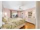 Light-filled bedroom features hardwood floors, pink walls, and a bright white wicker dresser at 1537 Eastover Ter, The Villages, FL 32162