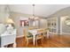 Elegant dining room featuring hardwood floors, a chandelier, and views into the kitchen at 1537 Eastover Ter, The Villages, FL 32162