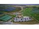 Aerial view of a golf course community, complete with lakes, tennis courts, and parking areas at 1614 Moon Valley Dr, Davenport, FL 33896