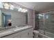 Modern bathroom featuring double sinks with a granite countertop and a glass-enclosed shower at 1614 Moon Valley Dr, Davenport, FL 33896