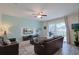 Comfortable living room with a sofa, a wall-mounted TV, and large sliding glass doors to the pool at 1614 Moon Valley Dr, Davenport, FL 33896