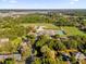 Expansive aerial view showcasing sports fields, mature trees, and neighborhood amenities in a scenic community setting at 1620 N Rhodes St, Mount Dora, FL 32757