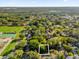 The land plot, as seen from the air, is surrounded by trees and is located in a neighborhood close to a park and tennis courts at 1620 N Rhodes St, Mount Dora, FL 32757