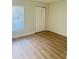 Bedroom featuring wood-look flooring, a window with blinds, and a closet at 1661 Stafford Springs Blvd, Mount Dora, FL 32757