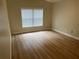 Bedroom featuring wood-look floors and a window with blinds at 1661 Stafford Springs Blvd, Mount Dora, FL 32757