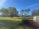 Scenic view of the golf course with mature trees under a clear blue sky at 1661 Stafford Springs Blvd, Mount Dora, FL 32757