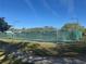 Tennis court with green fencing and an open blue sky at 1661 Stafford Springs Blvd, Mount Dora, FL 32757