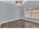 Bright bedroom featuring a ceiling fan, modern window blinds, and stylish wood-look flooring at 16628 Citrus Pkwy, Clermont, FL 34714