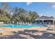 Large community pool surrounded by lounge chairs and lush trees, perfect for relaxing and socializing at 16628 Citrus Pkwy, Clermont, FL 34714