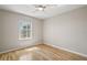 A bright bedroom featuring light walls, wood floors, and a window with natural light at 17051 Se 115Th Terrace Rd, Summerfield, FL 34491