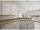 Well-lit kitchen featuring sleek white cabinets and a breakfast bar, perfect for casual dining at 17051 Se 115Th Terrace Rd, Summerfield, FL 34491