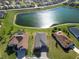 Aerial view of houses with driveways next to a scenic lake on a sunny day at 17108 Se 111Th Terrace Rd, Summerfield, FL 34491