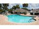 Spacious community pool with lounge chairs and tables, surrounded by palm trees and landscaping at 17108 Se 111Th Terrace Rd, Summerfield, FL 34491