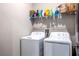 A convenient laundry room with a washer, dryer, and storage shelf above at 17108 Se 111Th Terrace Rd, Summerfield, FL 34491