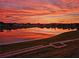 Beautiful pond reflecting a vibrant sunset sky in a tranquil community setting, perfect for serene evening strolls at 17108 Se 111Th Terrace Rd, Summerfield, FL 34491