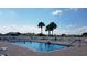 Outdoor swimming pool surrounded by lounge chairs, palm trees, and beautiful clear blue sky at 17108 Se 111Th Terrace Rd, Summerfield, FL 34491