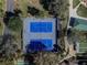 Aerial view of blue tennis courts surrounded by trees and walking paths in a well-maintained community at 17108 Se 111Th Terrace Rd, Summerfield, FL 34491