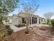 Rear view of a well-kept house, featuring a screened lanai and a landscaped yard with mature trees at 1713 El Nino St, The Villages, FL 32162