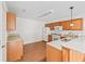 Well-lit kitchen with wooden cabinets, granite counters, and modern white appliances at 1713 El Nino St, The Villages, FL 32162