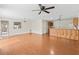 Inviting living room with hardwood floors, a ceiling fan, and an open layout to the kitchen area at 1713 El Nino St, The Villages, FL 32162