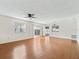 Comfortable living room featuring hardwood floors, a ceiling fan, and sliding glass doors for natural light at 1713 El Nino St, The Villages, FL 32162