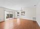 Bright living room featuring hardwood floors, white walls, and sliding glass doors leading to the outdoors at 1713 El Nino St, The Villages, FL 32162