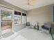 Relaxing screened porch featuring wicker chairs, a side table, and an overhead fan for outdoor enjoyment at 1713 El Nino St, The Villages, FL 32162