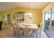 Bright dining room featuring vaulted ceilings, a chandelier, and access to the lanai at 17937 Se 107Th Ter, Summerfield, FL 34491