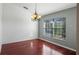 Dining room featuring wood floors, a chandelier, and a large window with blinds at 1801 Summit Oaks Cir, Minneola, FL 34715