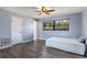 This bright bedroom has wood floors, a ceiling fan, and a large window with a beautiful view at 18944 Bates Ave, Eustis, FL 32736