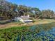 This waterfront property features a well-maintained lawn, mature trees, and direct access to the tranquil lake at 18944 Bates Ave, Eustis, FL 32736