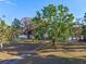 A scenic view of the property, featuring a winding driveway, expansive lawn, mature trees, and lake access at 18944 Bates Ave, Eustis, FL 32736