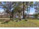 Lakeside yard featuring a firepit, stump seating, and mature trees at 18944 Bates Ave, Eustis, FL 32736