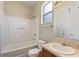 Bright bathroom features a shower-tub combo, a window and a vanity with a sink at 201 Andover Dr, Davenport, FL 33897