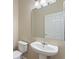 Bathroom features a pedestal sink and a toilet with a closed door in the background at 201 Andover Dr, Davenport, FL 33897