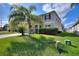 Two-story home with lush green lawn and mature palm trees at 201 Andover Dr, Davenport, FL 33897