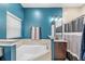 The bright bathroom features a soaking tub, a large vanity with granite countertops, and a separate shower area at 215 Elm Ct, Kissimmee, FL 34759