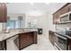 Modern kitchen with stainless steel appliances, granite countertops, and tiled floors at 215 Elm Ct, Kissimmee, FL 34759