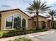 Community clubhouse exterior with arched windows, palm trees, and lush landscaping at 2313 Hamilton Ridge Road, Clermont, FL 34715