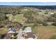 An aerial view of homes near a golf course, surrounded by lush greenery and mature trees, in a serene setting at 25274 Lost Oak Cir, Leesburg, FL 34748