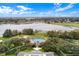 Aerial view of resort style pool surrounded by mature trees, a lake, and beautiful landscaping at 25274 Lost Oak Cir, Leesburg, FL 34748