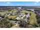 Aerial view features residences near green spaces and a pond, enhanced by clear blue skies and a picturesque horizon at 25274 Lost Oak Cir, Leesburg, FL 34748